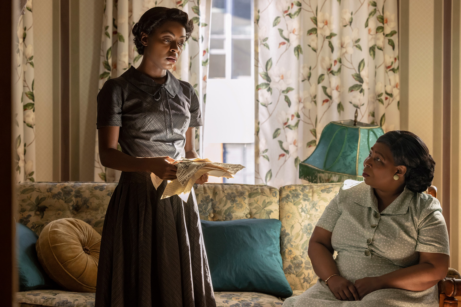TILL film still featuring Danielle Deadwyler and Whoopi Goldberg in a living room, the former holding news clipping.