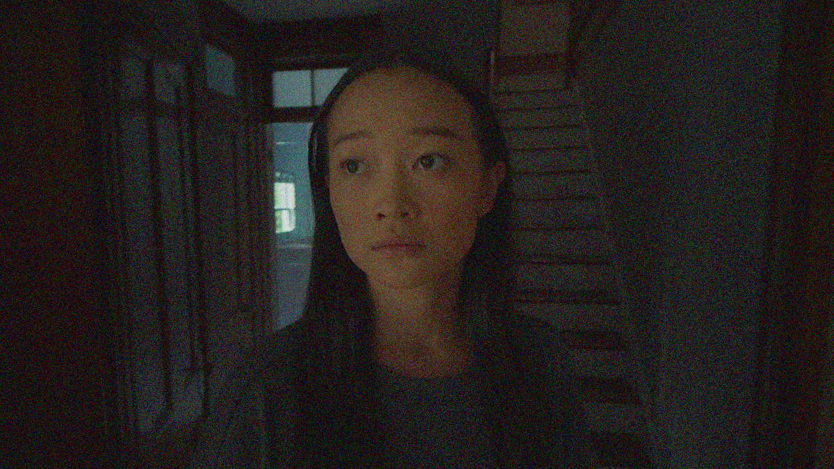 A close-up of Callina Liang looking just off from the camera lens at the bottom of a staircase.