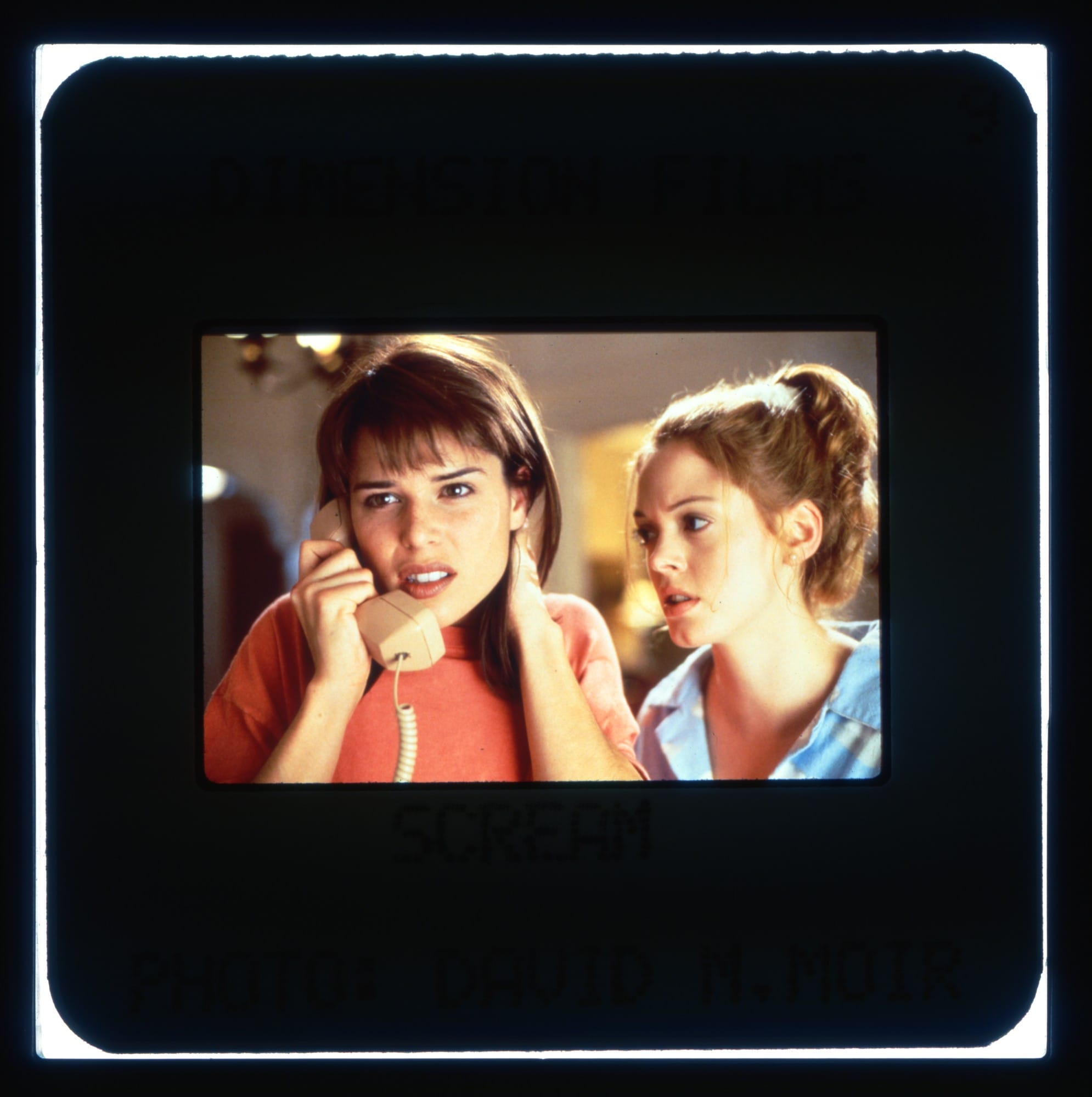 Neve Campbell (phone to ear) and Rose McGowan (looking at Neve) in Wes Craven's SCREAM.