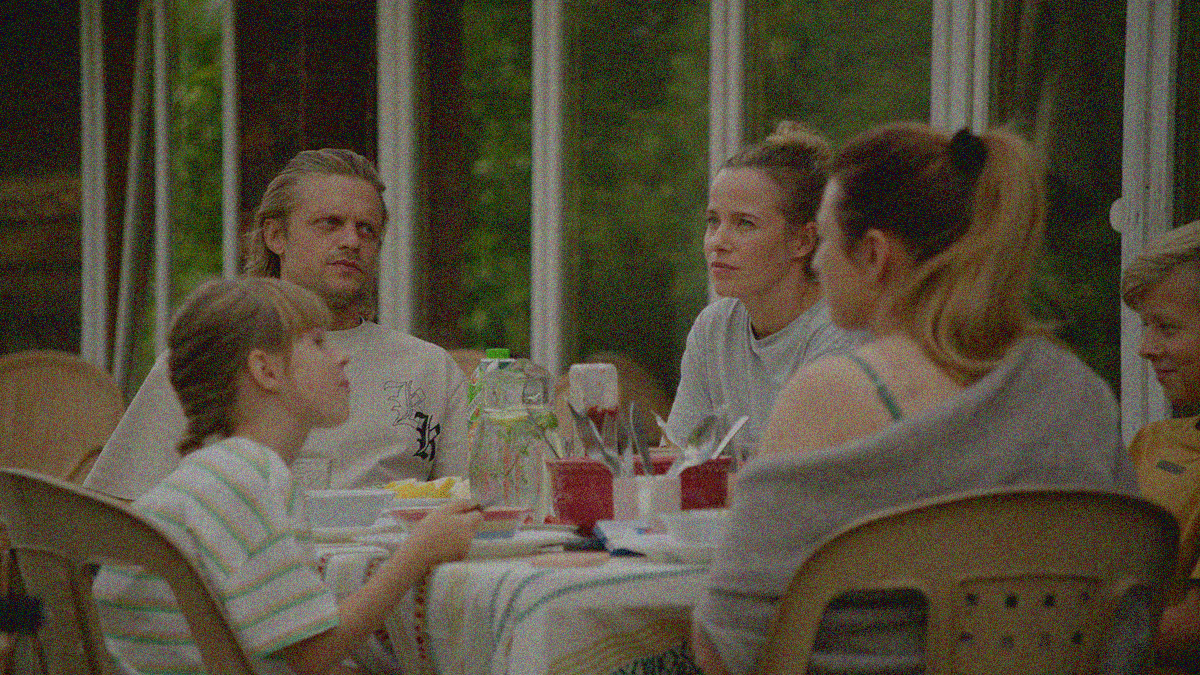 A family sits at an outdoor table for a meal.
