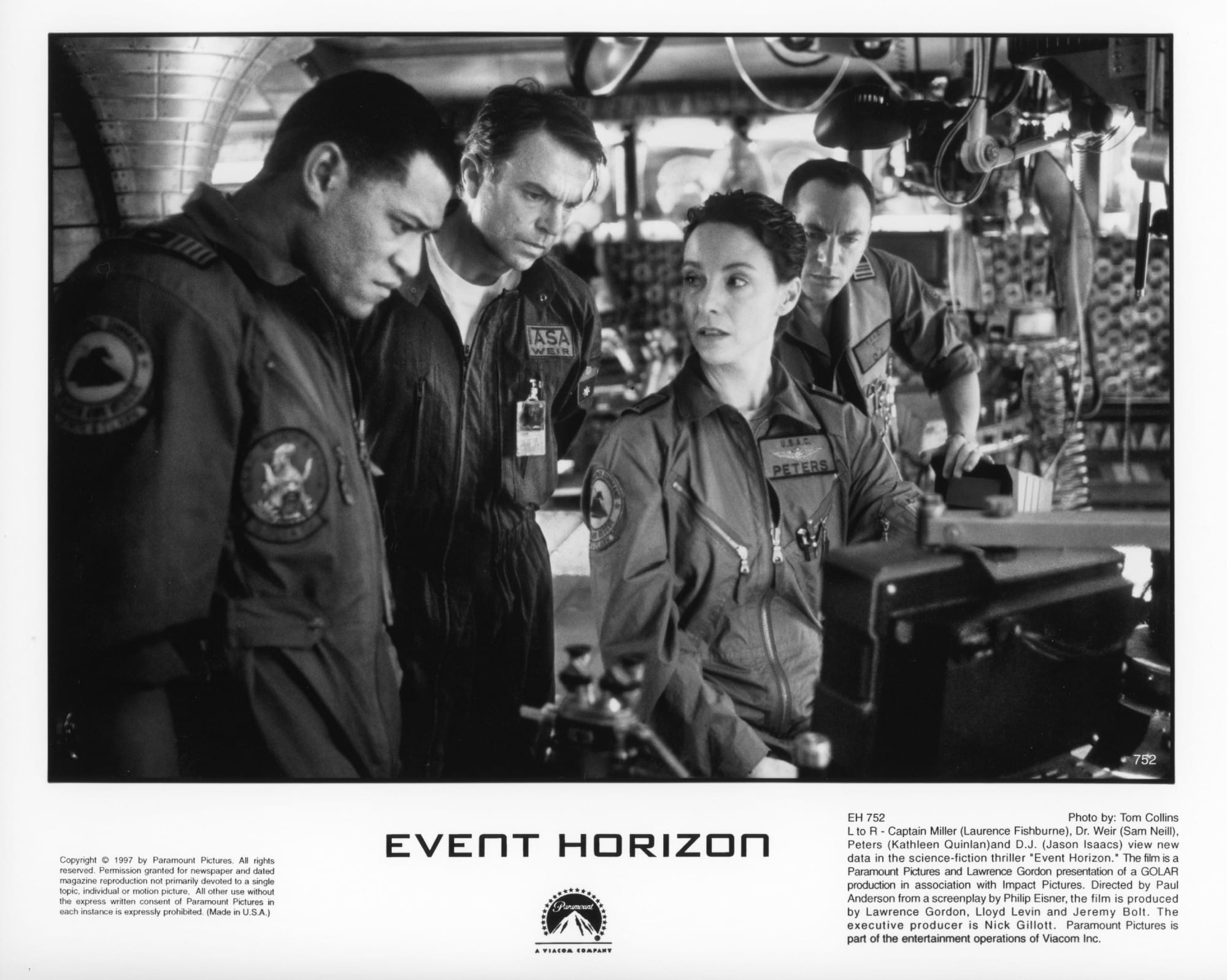 Four members of a space crew consider data on a screen.