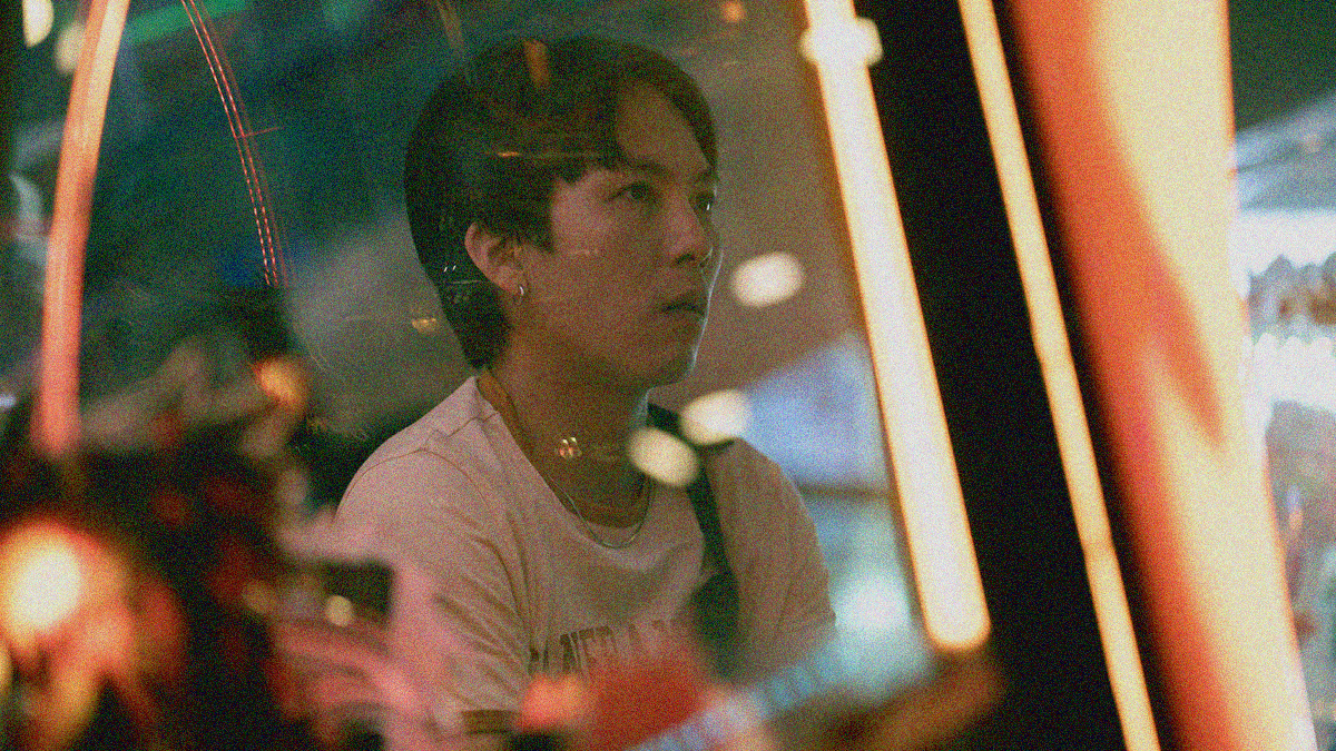 A man seen through a pane of glass staring off-screen.