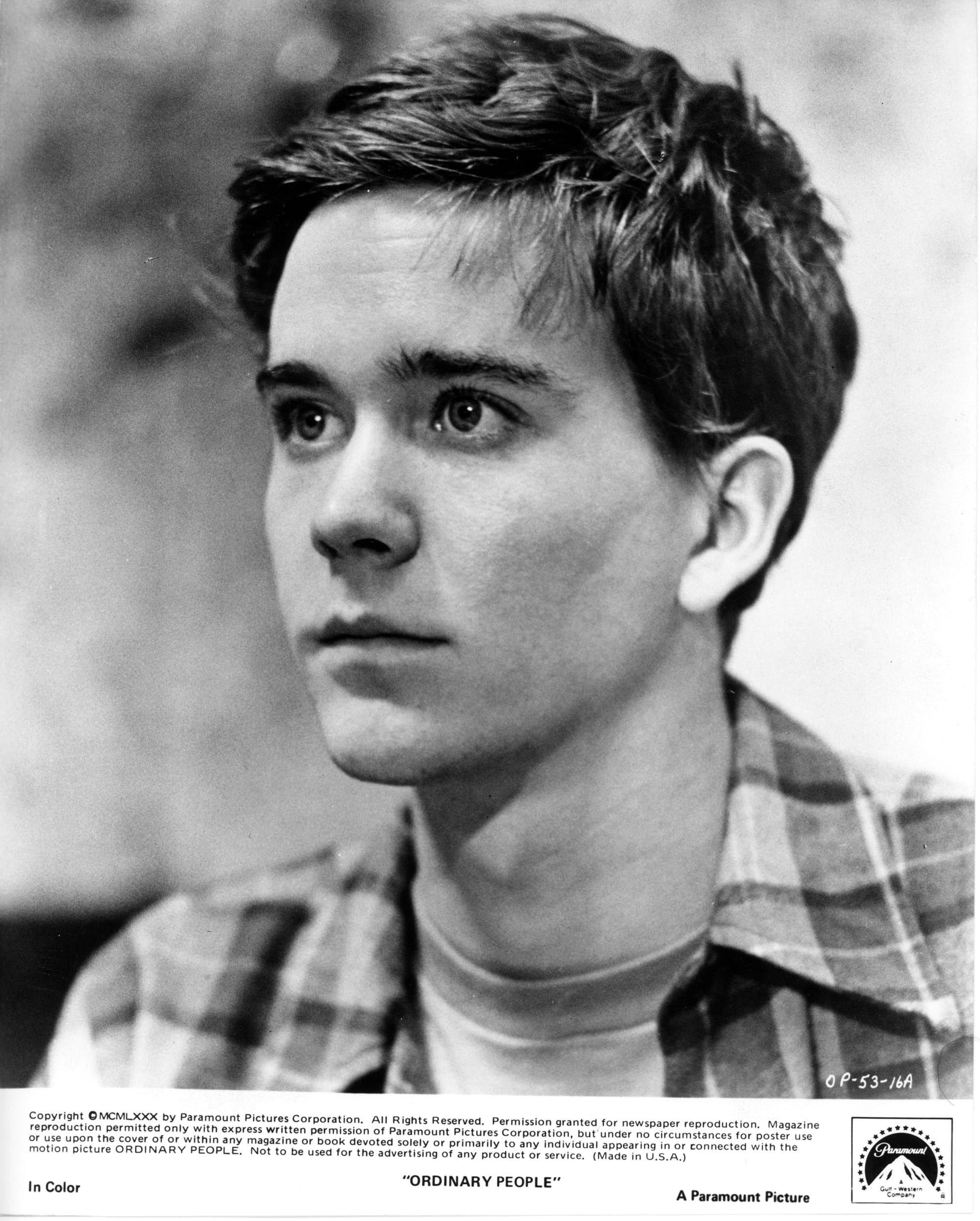 A young man shown in close-up from shoulders upin 3/4 view, looking off-screen to the left.