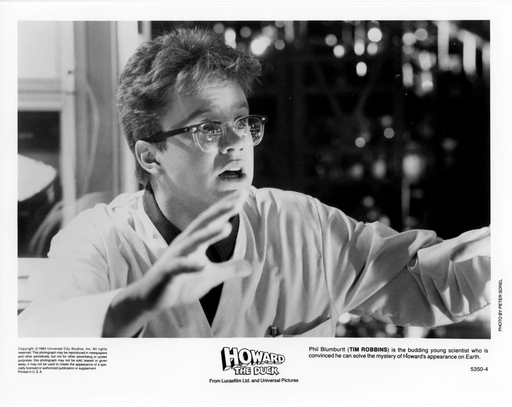 B&W Publicity Photo: A man looks surprised with eyes wide and mouth open, hands outstretched in front of him. He looks off-screen right.