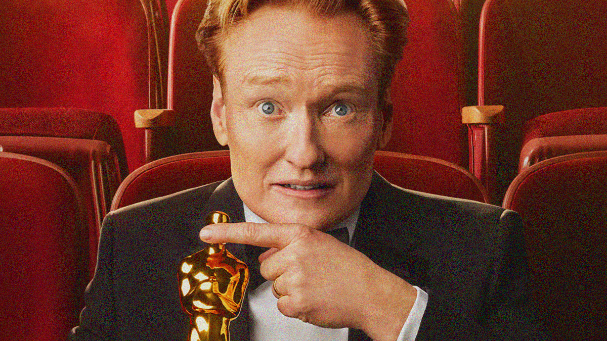 An image of Conan O'Brien from the official 98th Academy Awards poster where he's seated in an auditorium holding an Oscar in one hand and covering its eyes with the other.